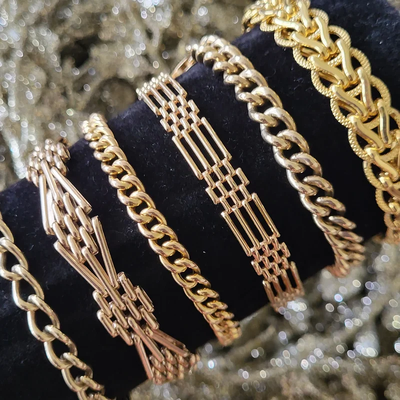 Seven antique gold bracelets displayed on a black velvet stand