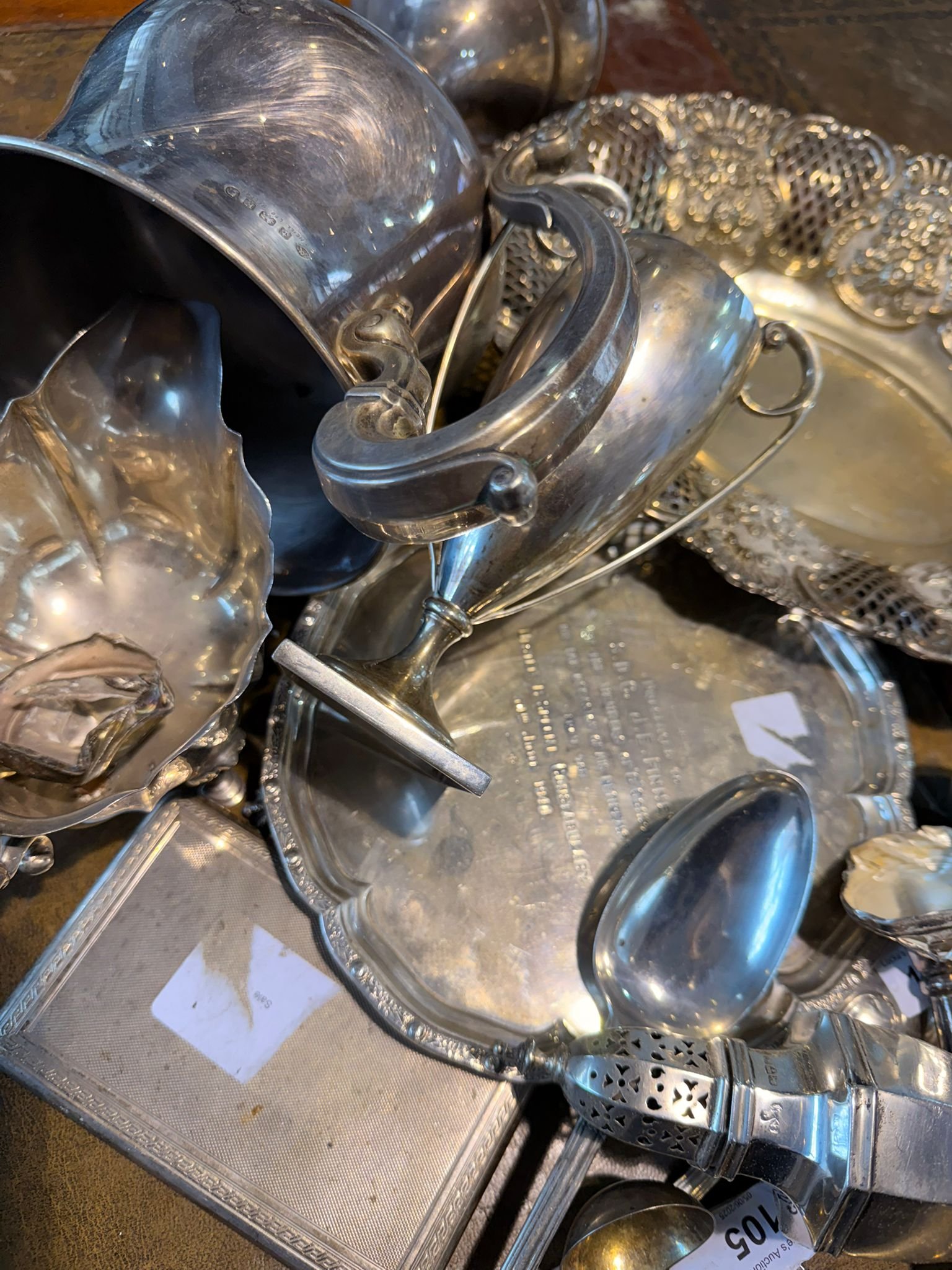 Silver items including cups, spoons and decorative pieces at auction